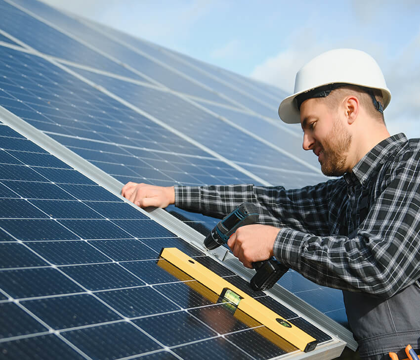 Monteur für Photovoltaik montiert ein Solarmodul auf einem Hausdach in der Nähe der Stadt Mainz